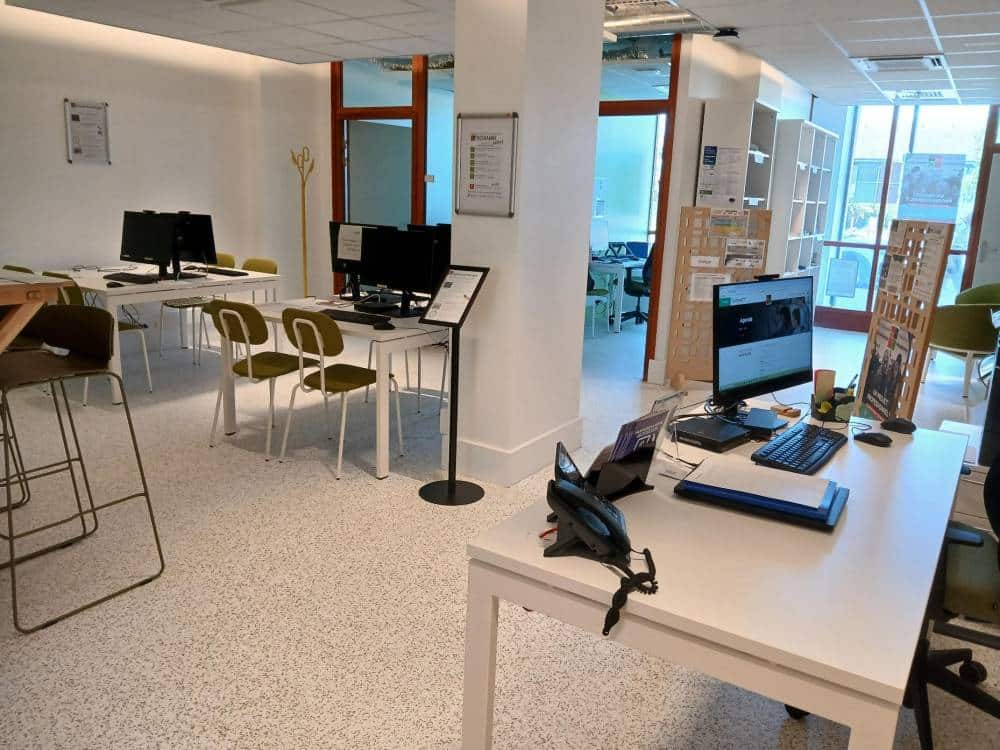salle avec tables, chaises, ordinateurs et espace documentation